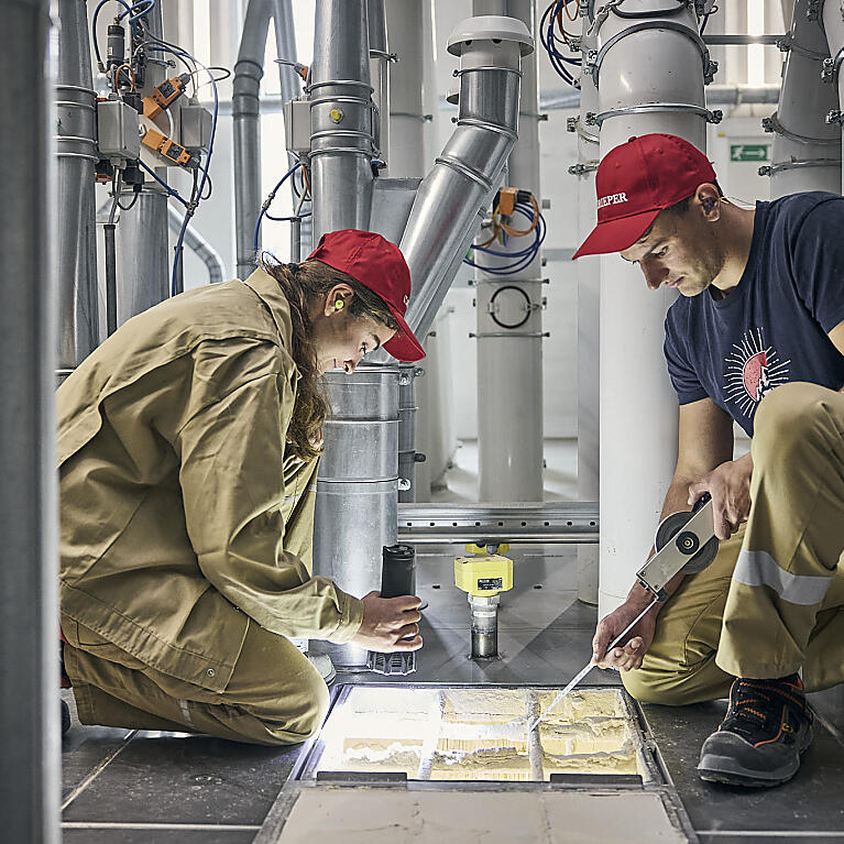 Eine Mitarbeiterin und eine Mitarbeiter von Rieper bei der Arbeit im Futtermittelwerk.